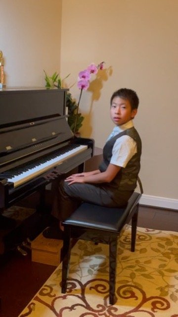 Xavier seated at the piano