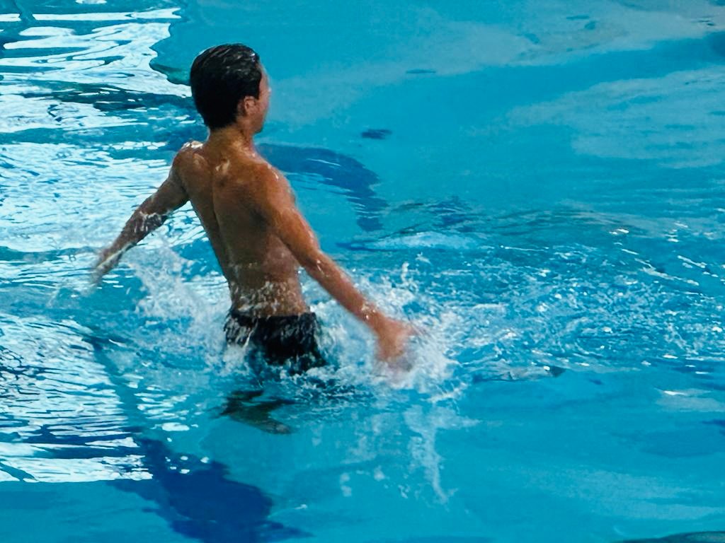 Xavier rising above the water during artistic swimming