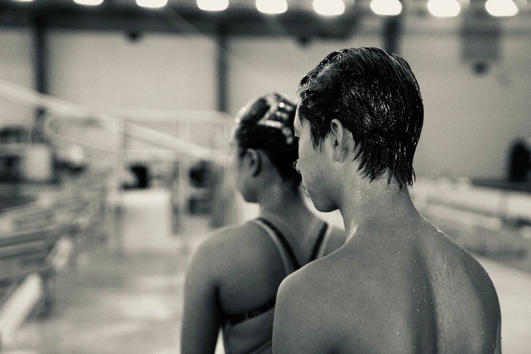 Black and white poolside photograph of Xavier and a teammate